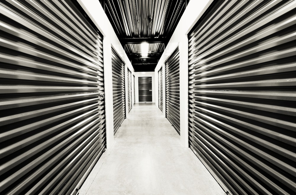 Cellule capitonnée d'un camion de déménagement Proconcept chargée de piles de cartons étiquetés, de caisses de transport et de mobilier protégé.